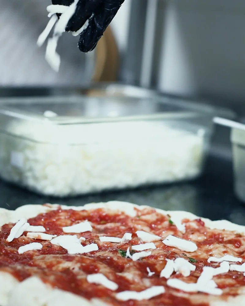 Pizza, topped by hand